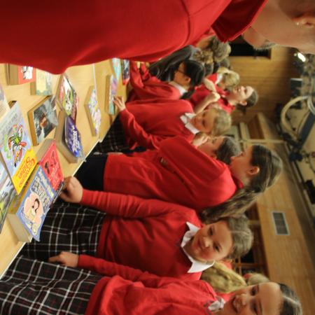 children looking at a table of books