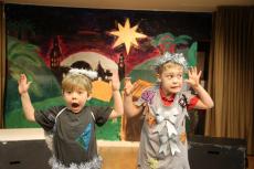 two young children dressed as an angel on stage