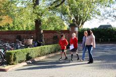 two school pupils taking visitors on a tour of the school site