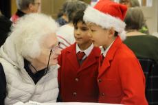 two children talking to a senior citizen at a christmas party