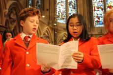 two school children singing in a chapel