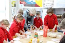 children kneading dough to make pizzas