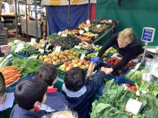 children buying vegetables at a market