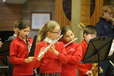 children performing a christmas concert in a hall with instruments