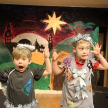 two young children dressed as an angel on stage