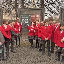 St John's College Choir choristers outside a poster of their tour